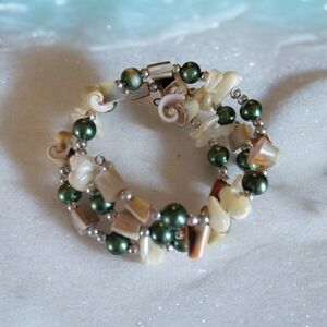 Multi-strand bracelet featuring pearls and seashell accents.